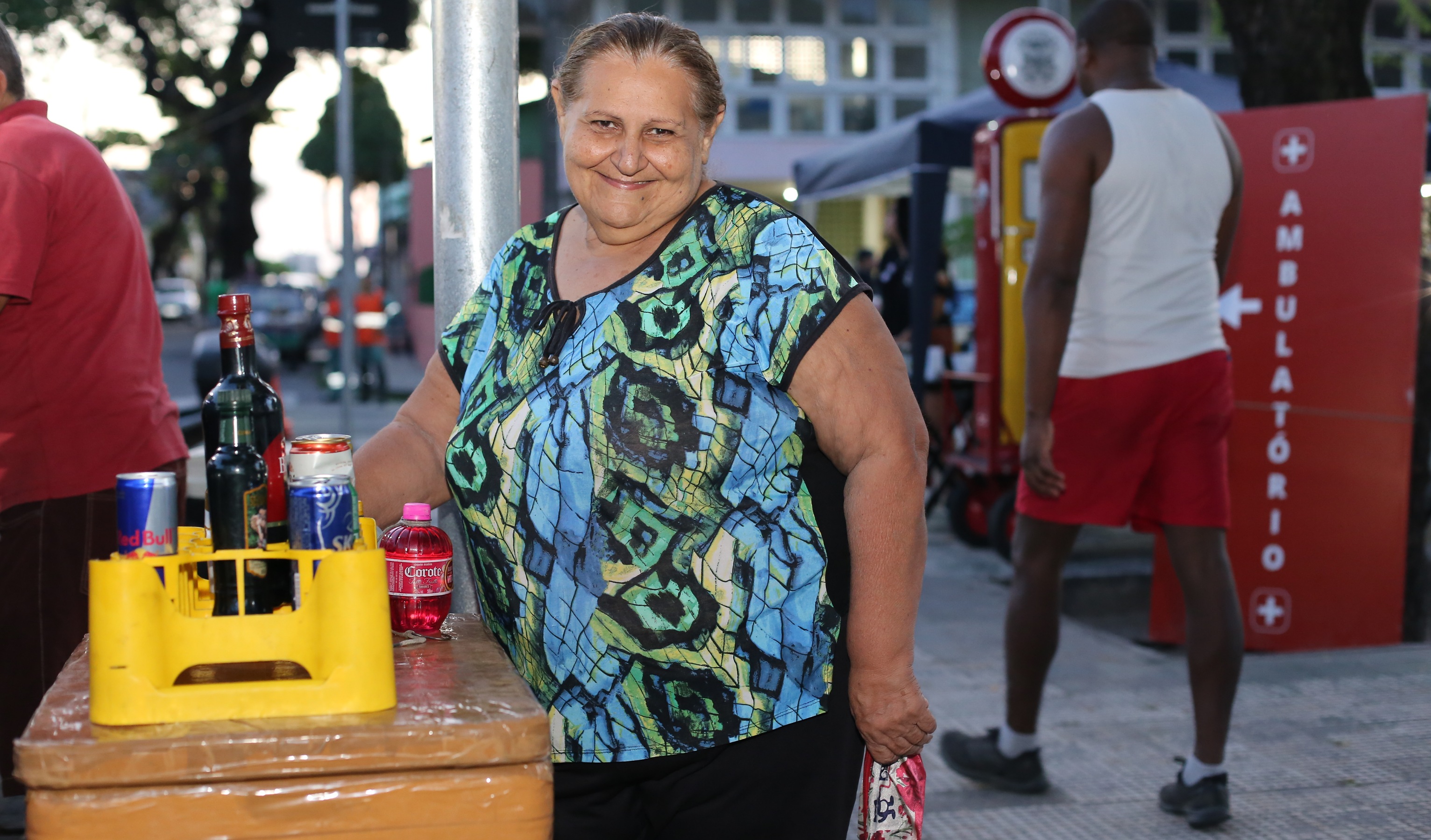 senhora sorrindo em frente a isopor com bebidas